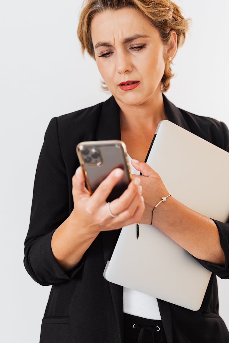  Woman Holding A Cell Phone And A Laptop