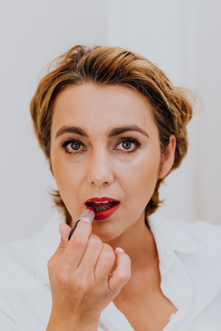 Close Up Photo Of A Woman Applying Lipstick