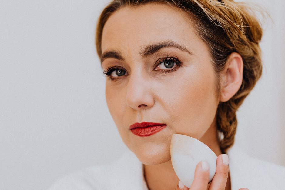 Close-up of a woman using a sponge for makeup application. Beauty and skincare concept.