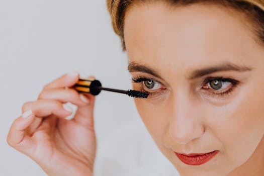 Elegant close-up shot of a woman applying mascara, highlighting beauty and makeup artistry.