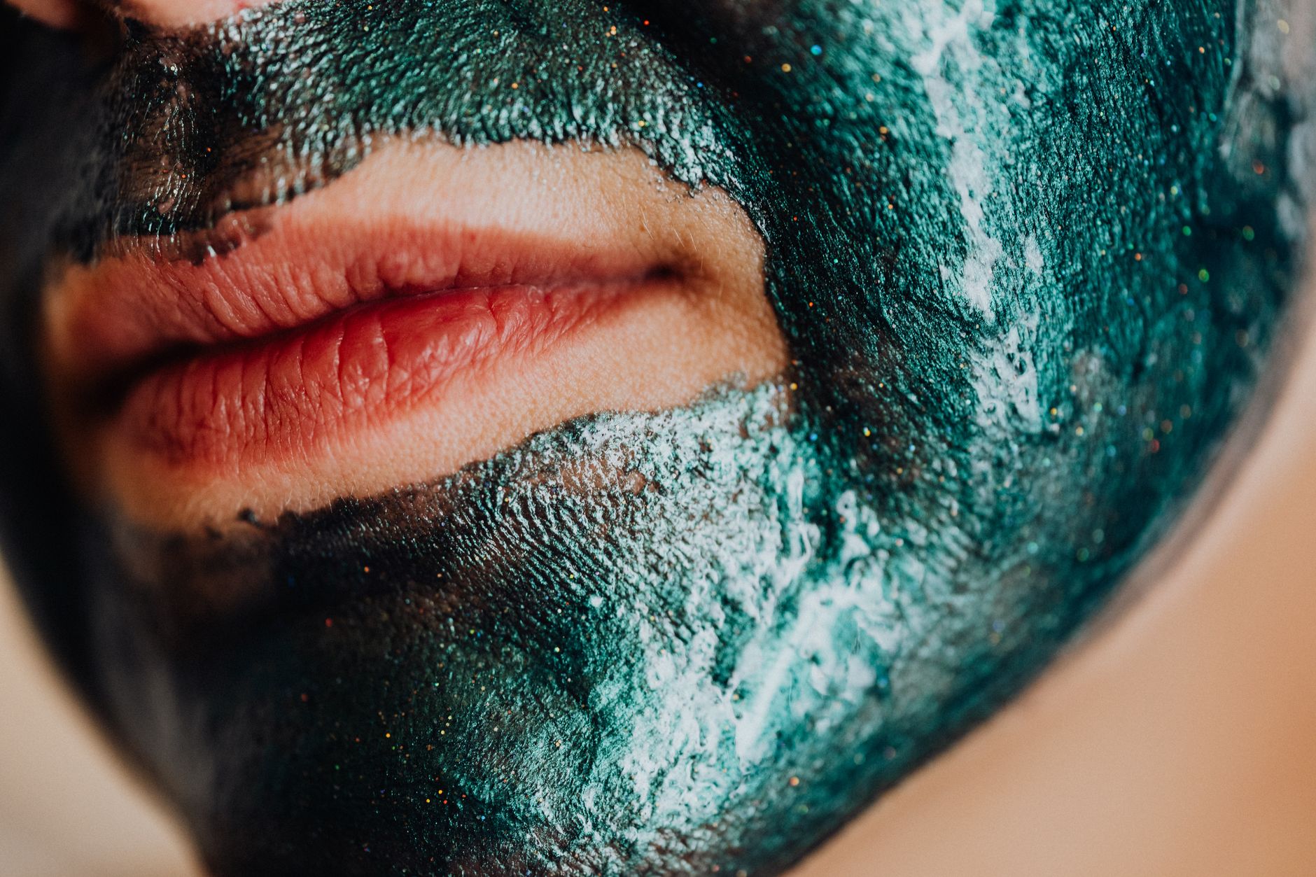 bentonite clay for spike protein detox — A detailed close-up shot of lips with a green facial mask applied.