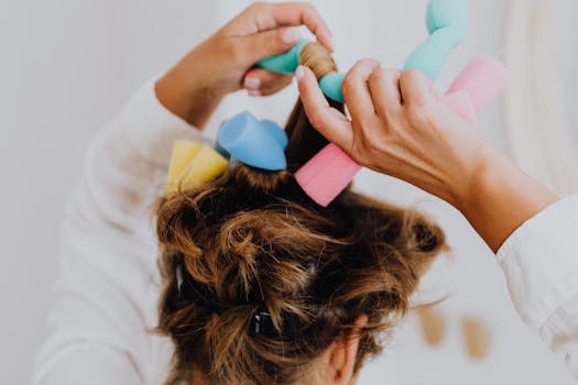 Woman styling hair with soft foam curlers in a close-up view.