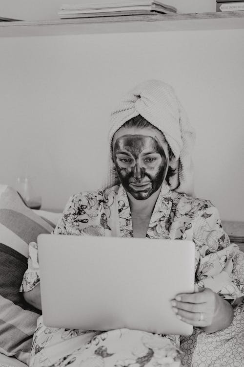 Free Woman In Facial Mask Using a Laptop Stock Photo