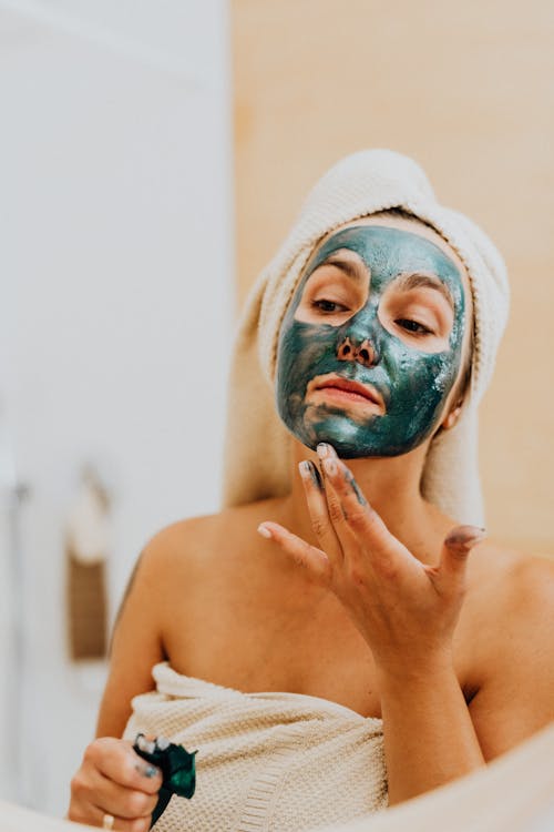 Free Close Up Photo of Woman Applying Cosmetic Mask on Her Face Stock Photo