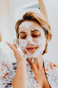Adult woman applying a fluffy foam mask, promoting relaxation and skincare.