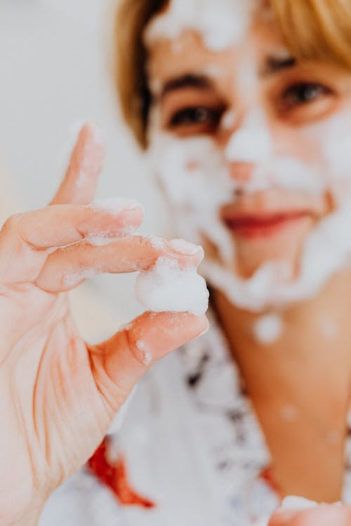 Hand of Person Covered in Soap Holding Ball of Foam