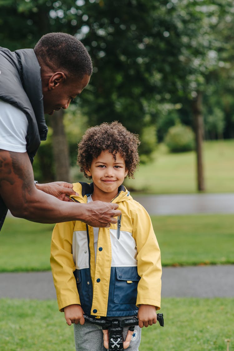 Black Father Putting On Jacket On Son