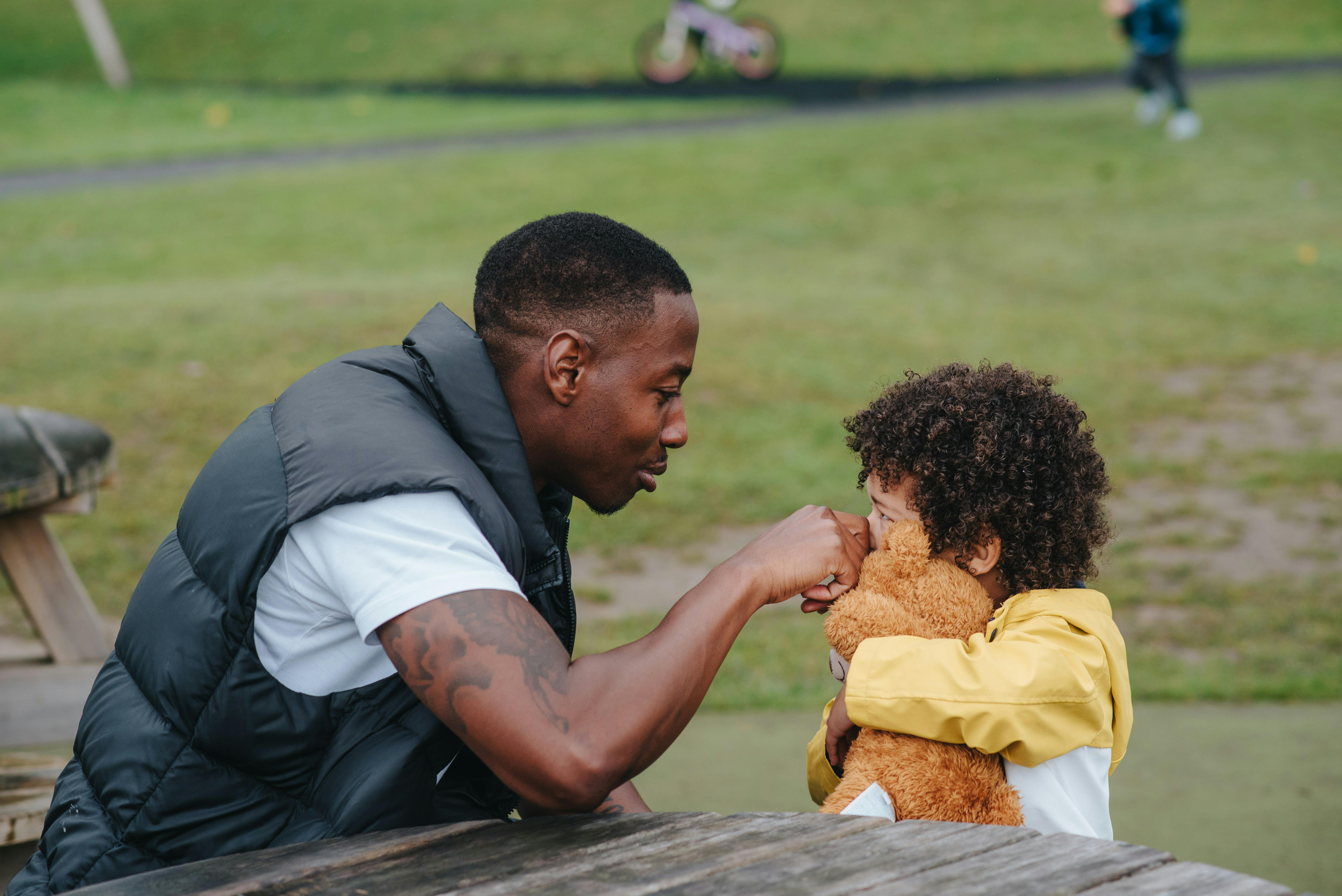 black father touching nose of son