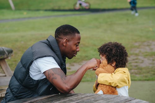 Black father touching nose of son