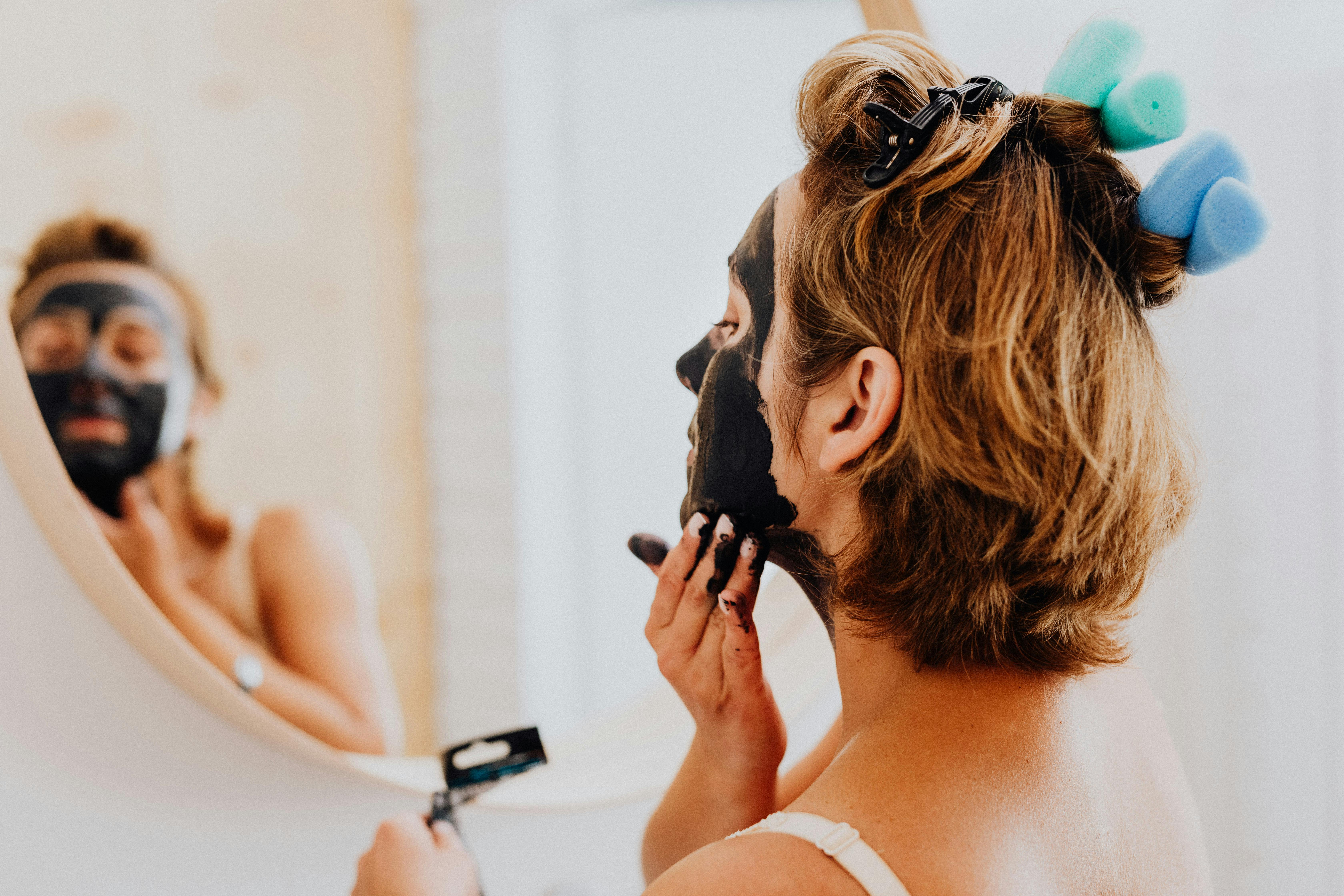 woman applying a facial mask