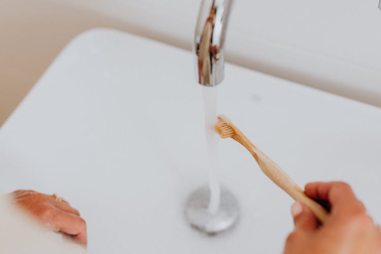 Woman Using A Bamboo Toothbrush 