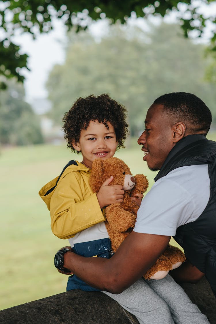 Black Kid With Toy And Father In Park