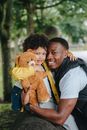 Happy father and son hugging while looking at camera