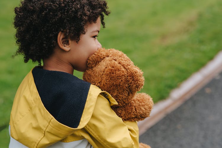 Crop Charming Ethnic Boy With Soft Toy Near Urban Lawn