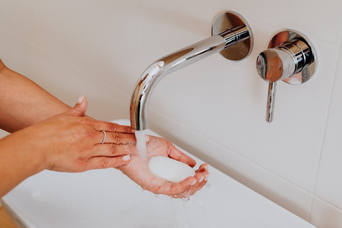 Person Holding Stainless Steel Faucet