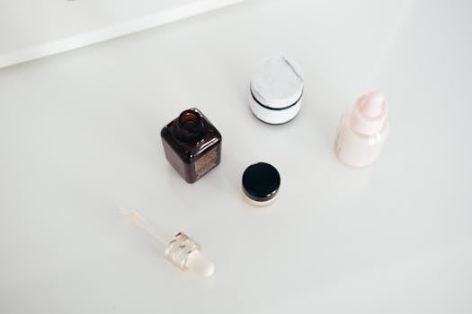 A flat lay of various skincare products including jars, a dropper, and a bottle on a white background.