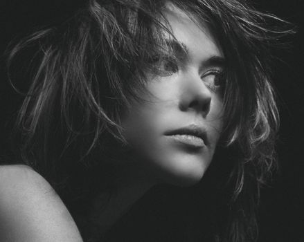Dramatic black and white portrait capturing a woman's intense expression.