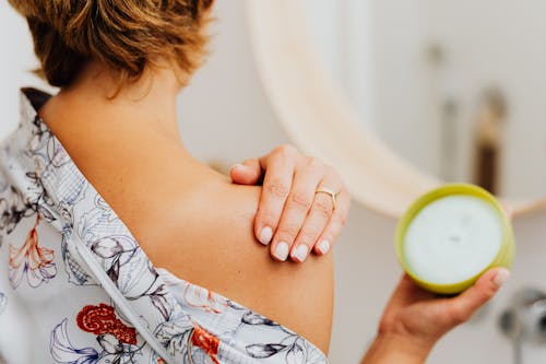 Free Woman Putting Cream on Shoulder Stock Photo