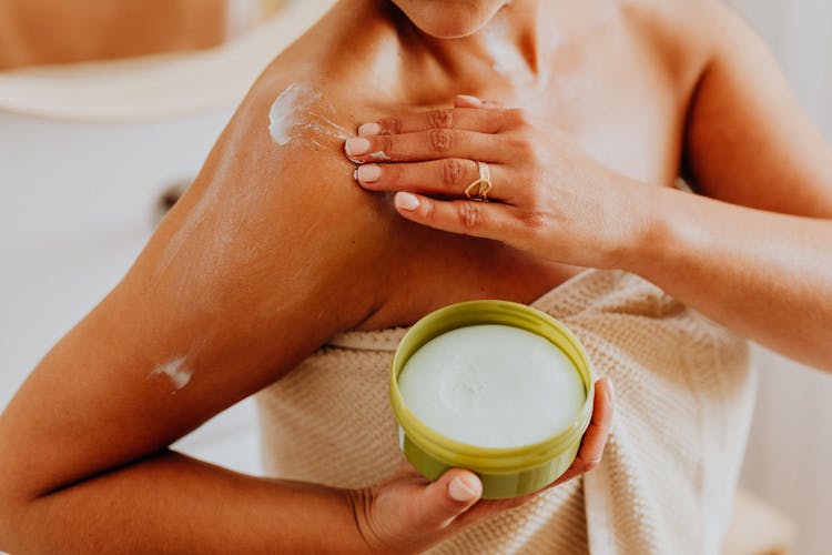 Woman Putting Cream On Skin