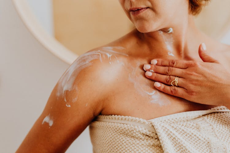 Woman Putting Cream On Skin