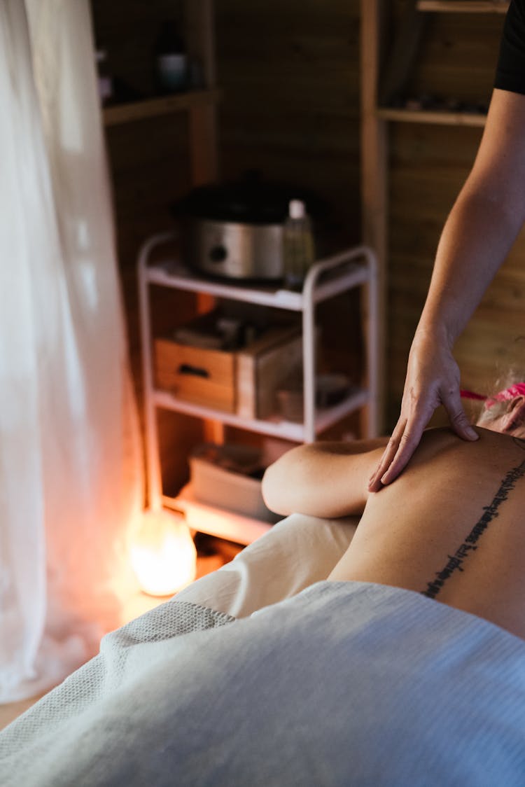 Crop Masseur Massaging Back Of Female Client