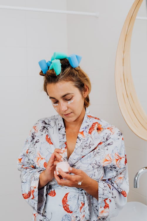 Woman in Robe Applying Face Cream