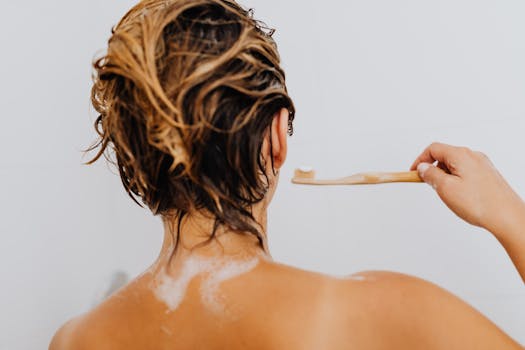Woman in shower holding a bamboo toothbrush, showing eco-friendly hygiene routine.