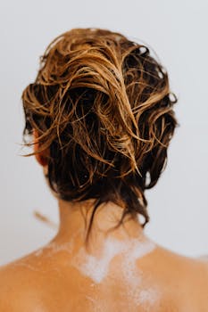 Close-up of wet blonde hair viewed from behind, capturing a moment of showering and wellness.