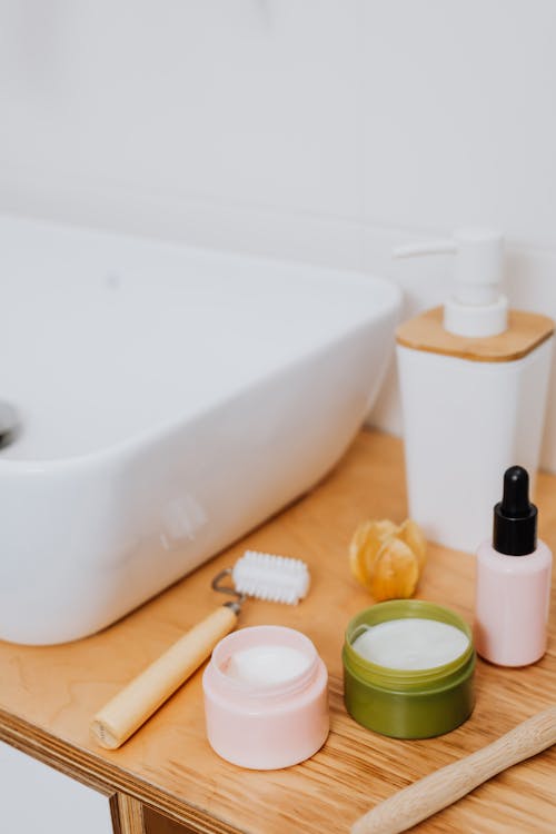 Beauty Products Next to a Sink in a Bathroom 