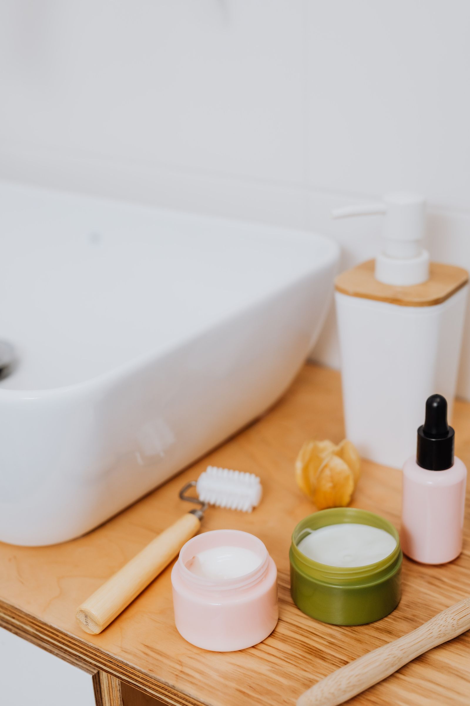 Organized skincare products beside a bathroom sink without people