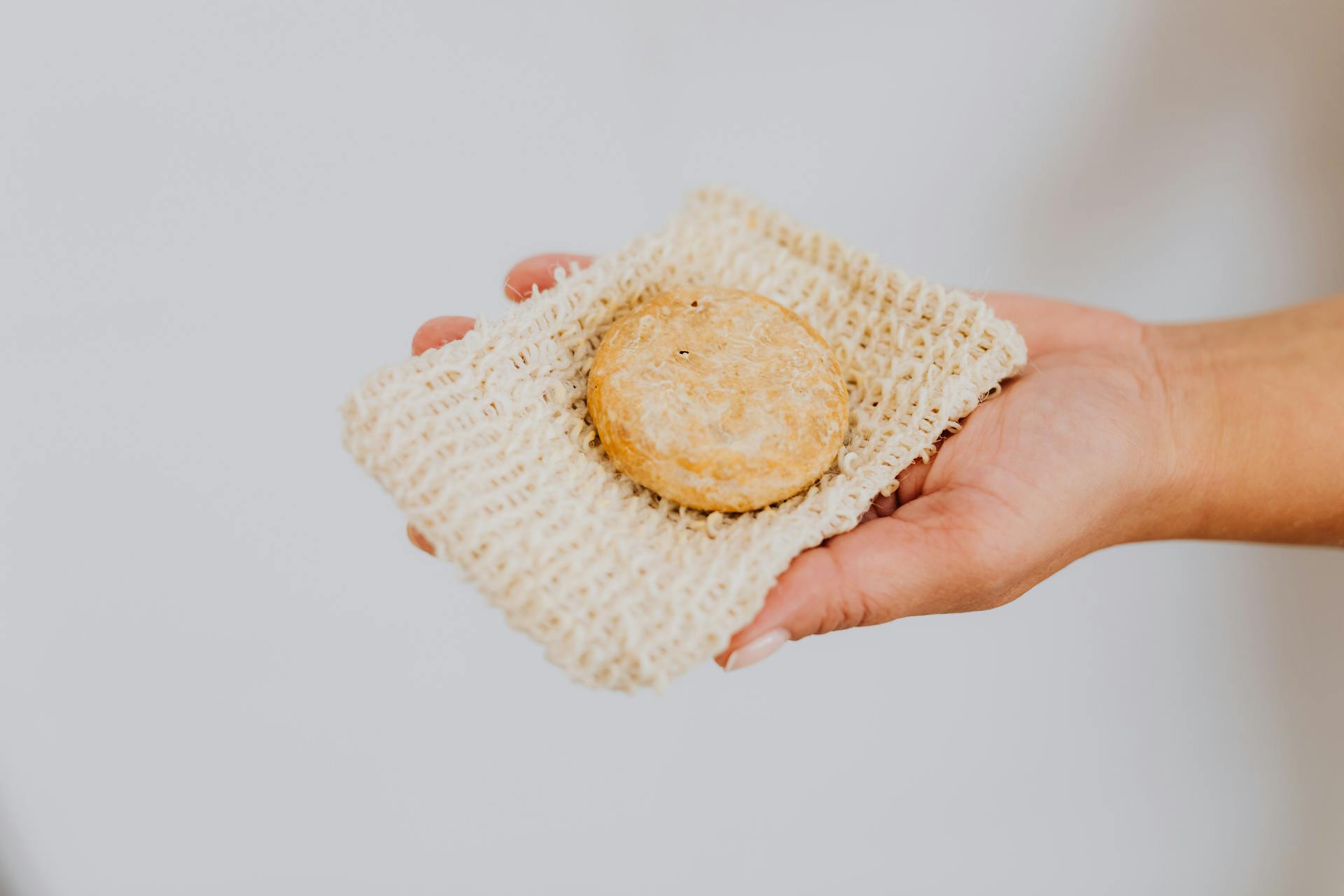 Close-up of Woman Holding a Sustainable Washing Cloth and a Soap Bar