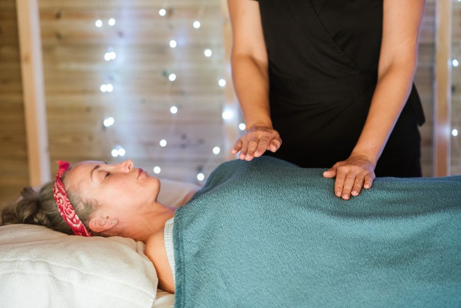 Practitioner performing hands-on tuina bodywork on a relaxed patient