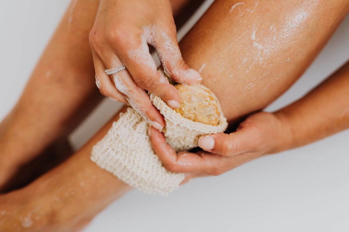 Woman exfoliating skin in shower