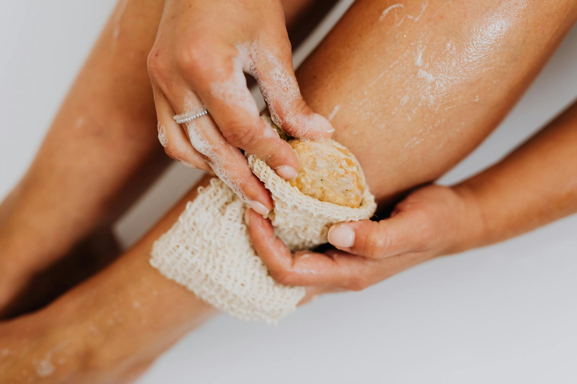 Person Using a Body Scrub on Legs