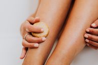 Person Using Soap on Legs