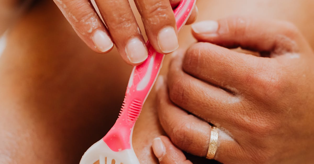 A woman applying moisturizer to her face in a gentle circular motion.