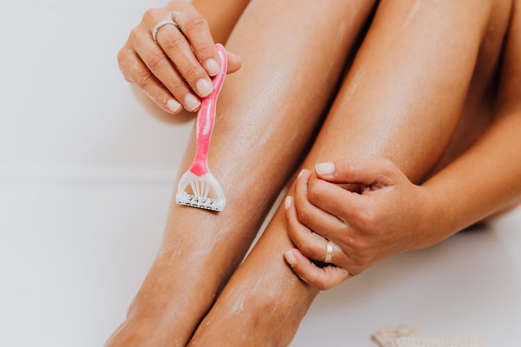 Person Using Razor On Legs