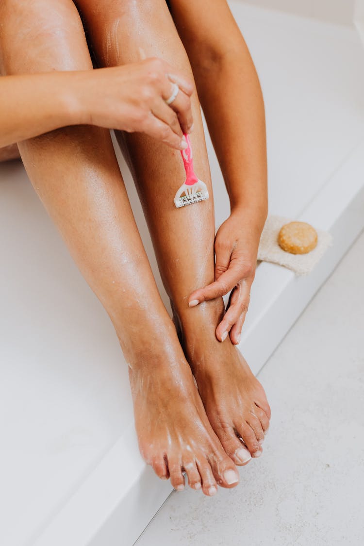 Woman Shaving Legs In Shower