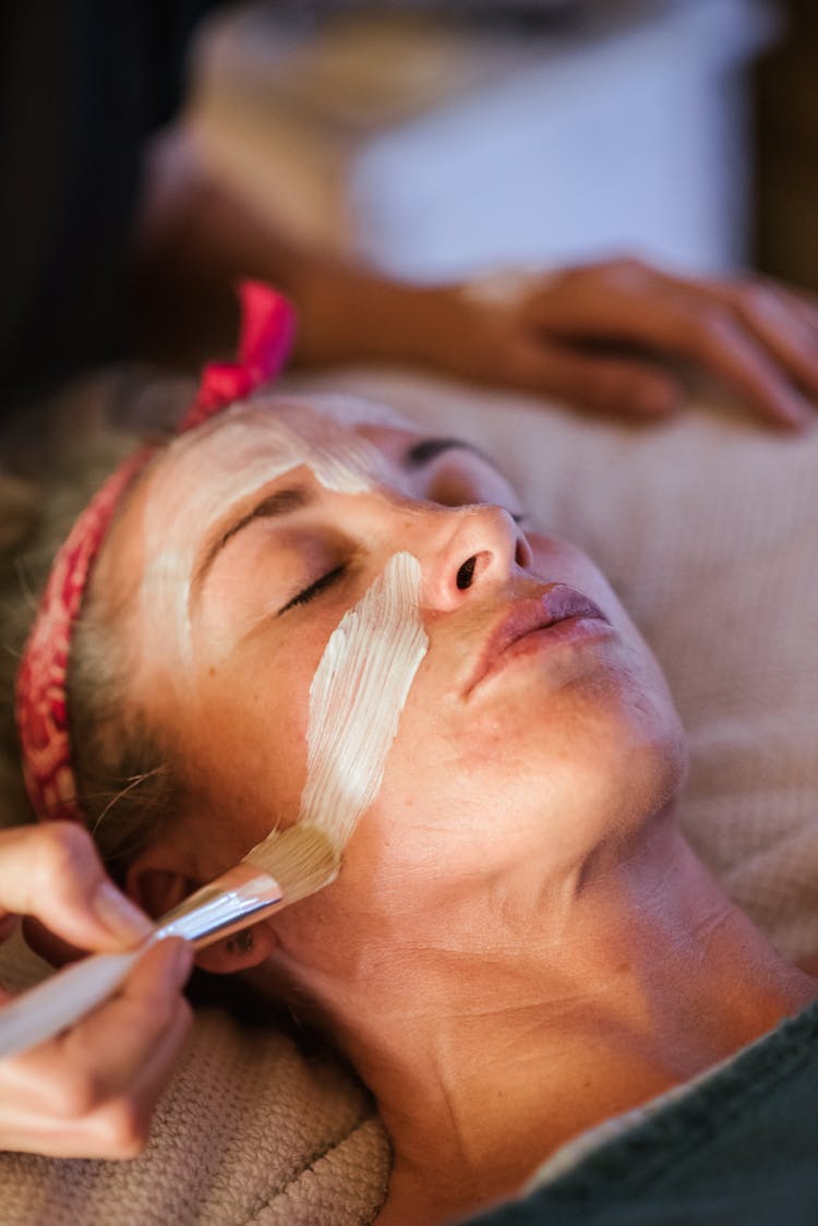 Woman Cleaning Face With Mask In Spa Center