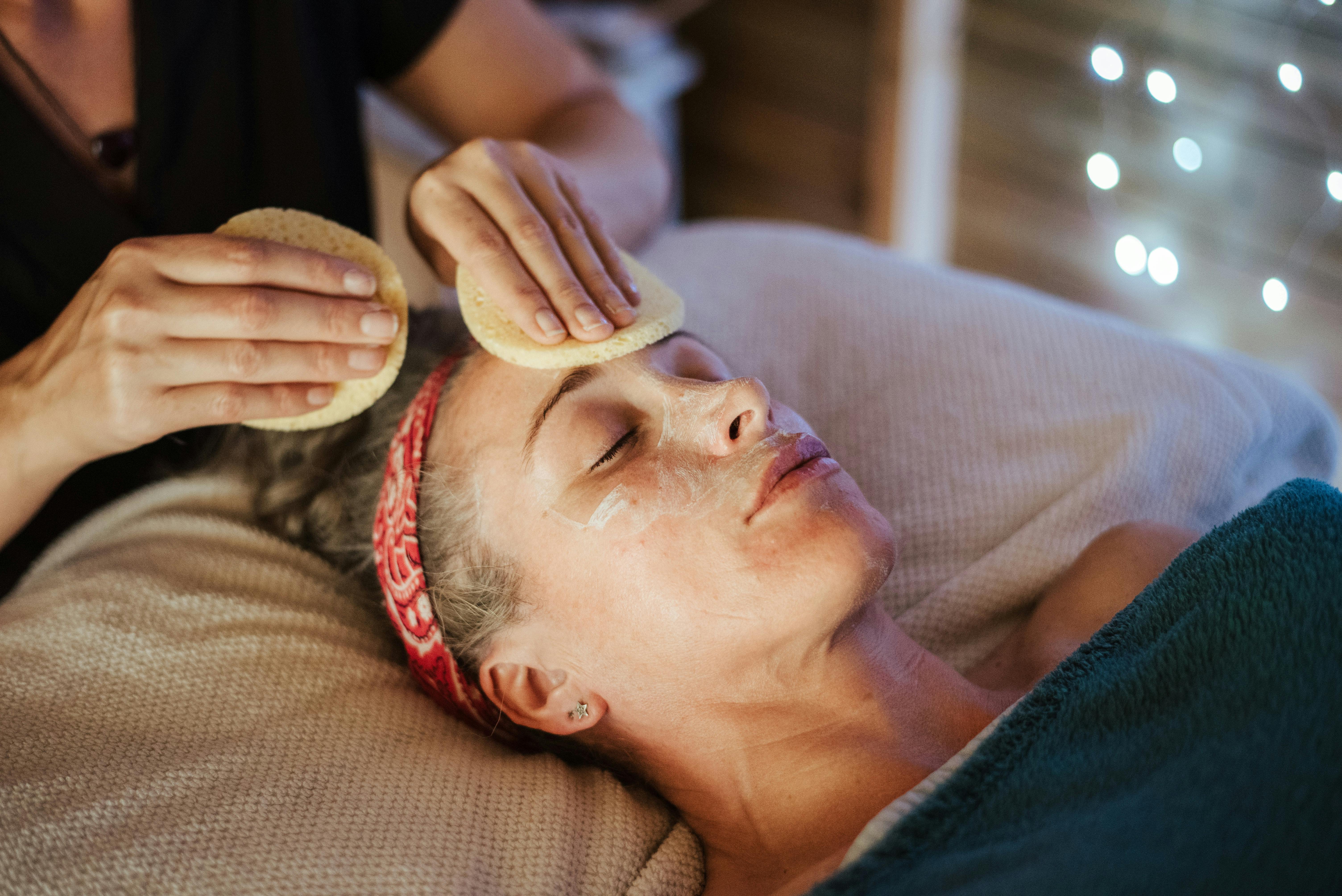 woman removing mask from face after massage