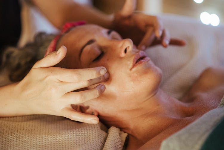 Lady Enjoying Face Massage From Masseur In Spa