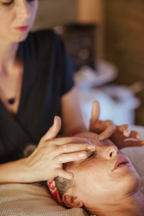 Женщина с закрытыми глазами получает массаж в салоне