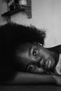 Crop frustrated black woman leaning on hand near wall