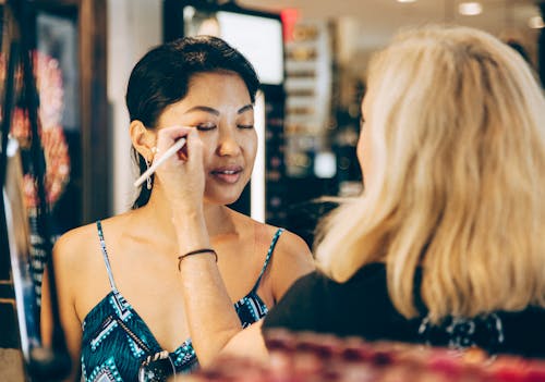 A Make-up Artist Applying Eyeshadow on Woman's Eyelid