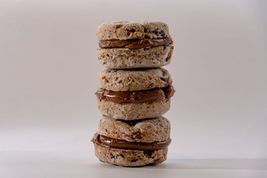 A stack of delicious chocolate-filled macaron cookies with a creamy filling.
