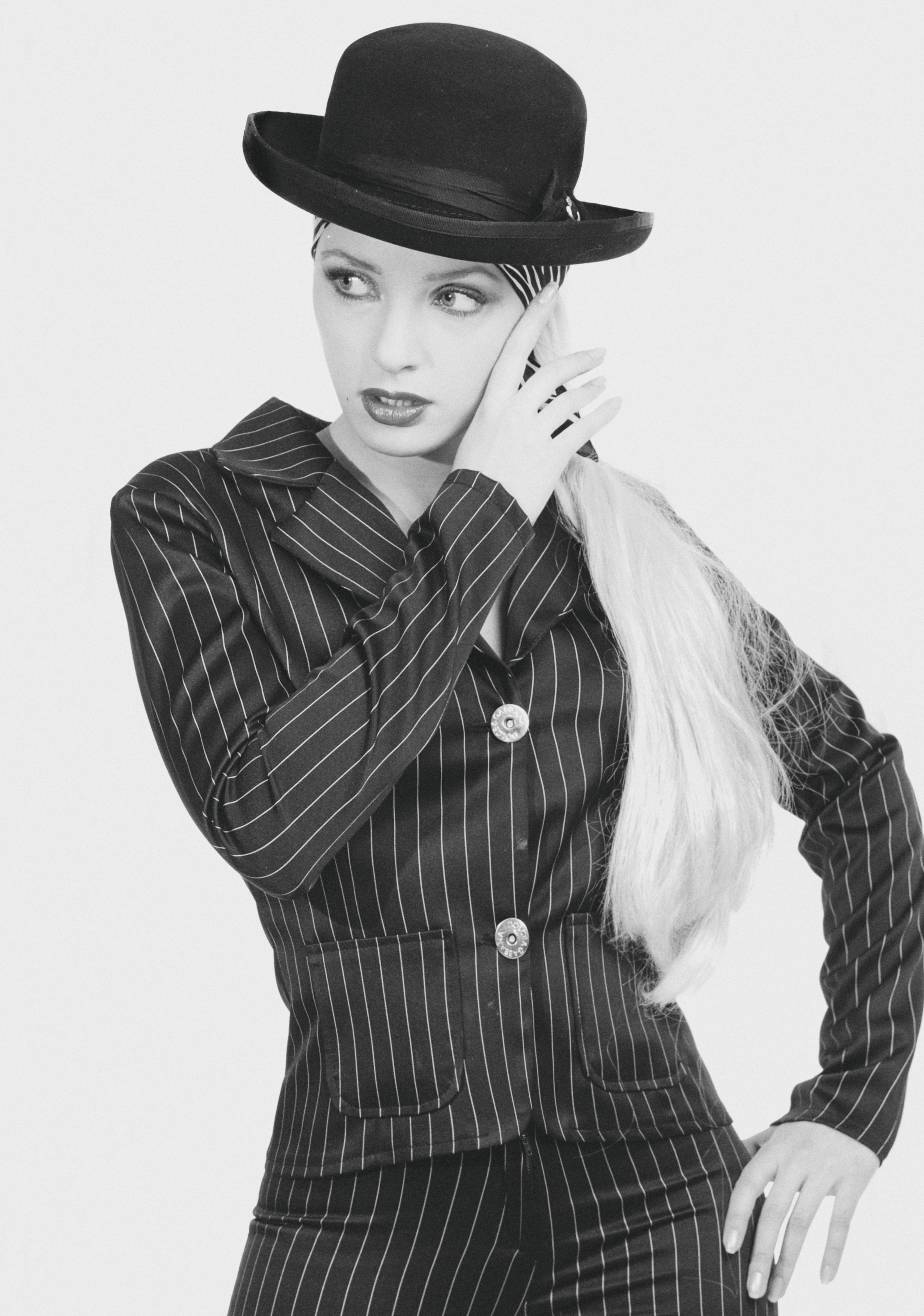 A Grayscale of a Woman in a Striped Suit and a Hat · Free Stock Photo