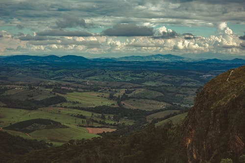 Green valley with mountains under cloudy sky