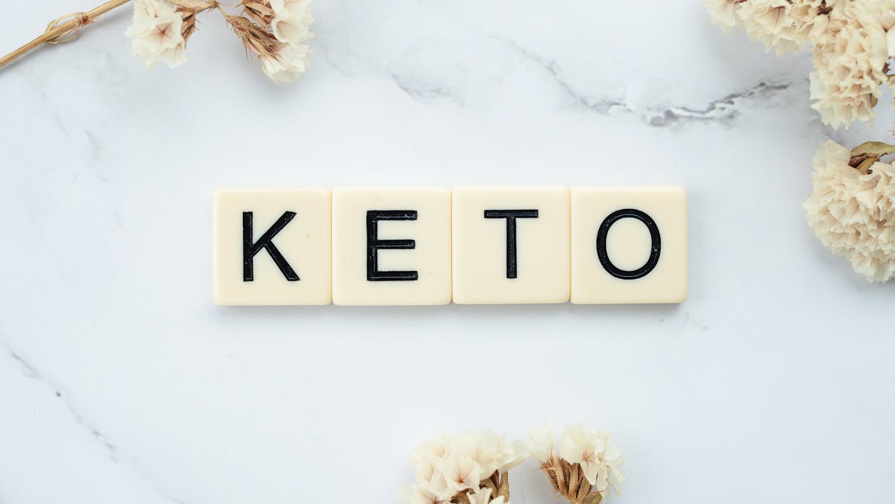 Free Scrabble Tiles Surrounded by White Flowers on a Marbled Surface Stock Photo