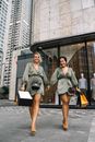 两名女子在城市中微笑着享受户外购物日