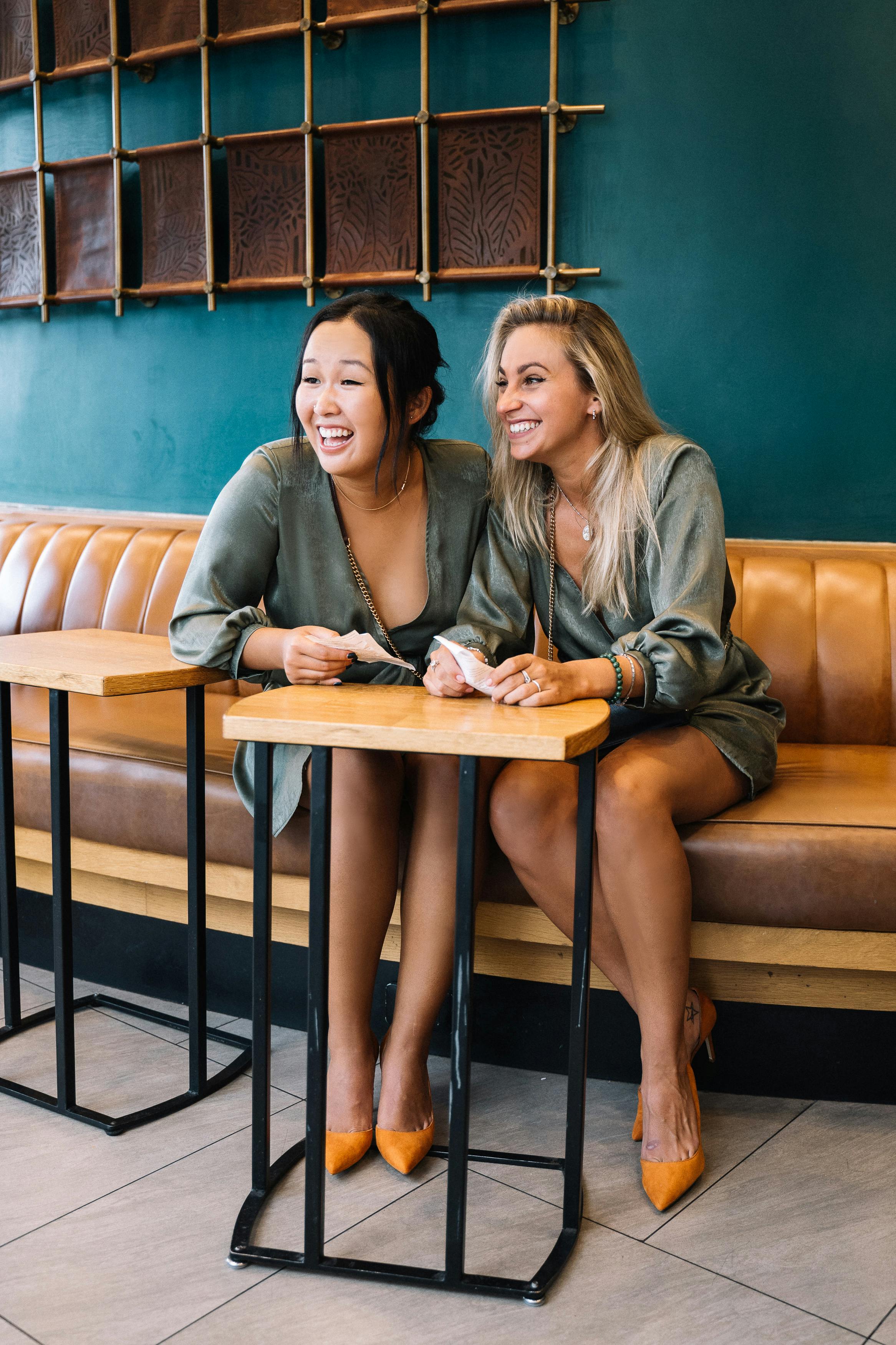 两名女子在一家时尚的咖啡馆里友好地笑着聊天